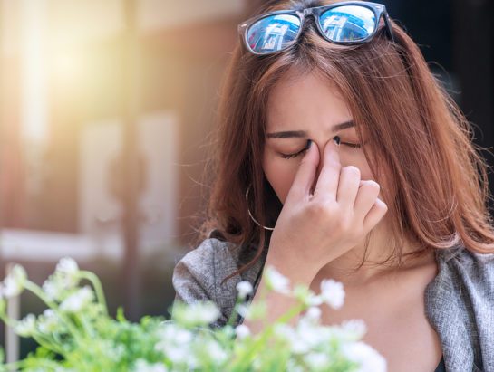 Tired Young Businesswoman Massaging Nose Bridge Feeling Eye Stra Tired young businesswoman massaging nose bridge feeling eye strain or headache trying to relieve pain. Overworked young woman have migraine feeling straining her eyes while sitting in garden.