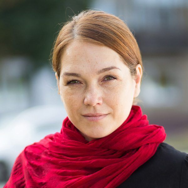 Portrait of caucasian middle aged woman looking at camera with soft look and smile outdoor